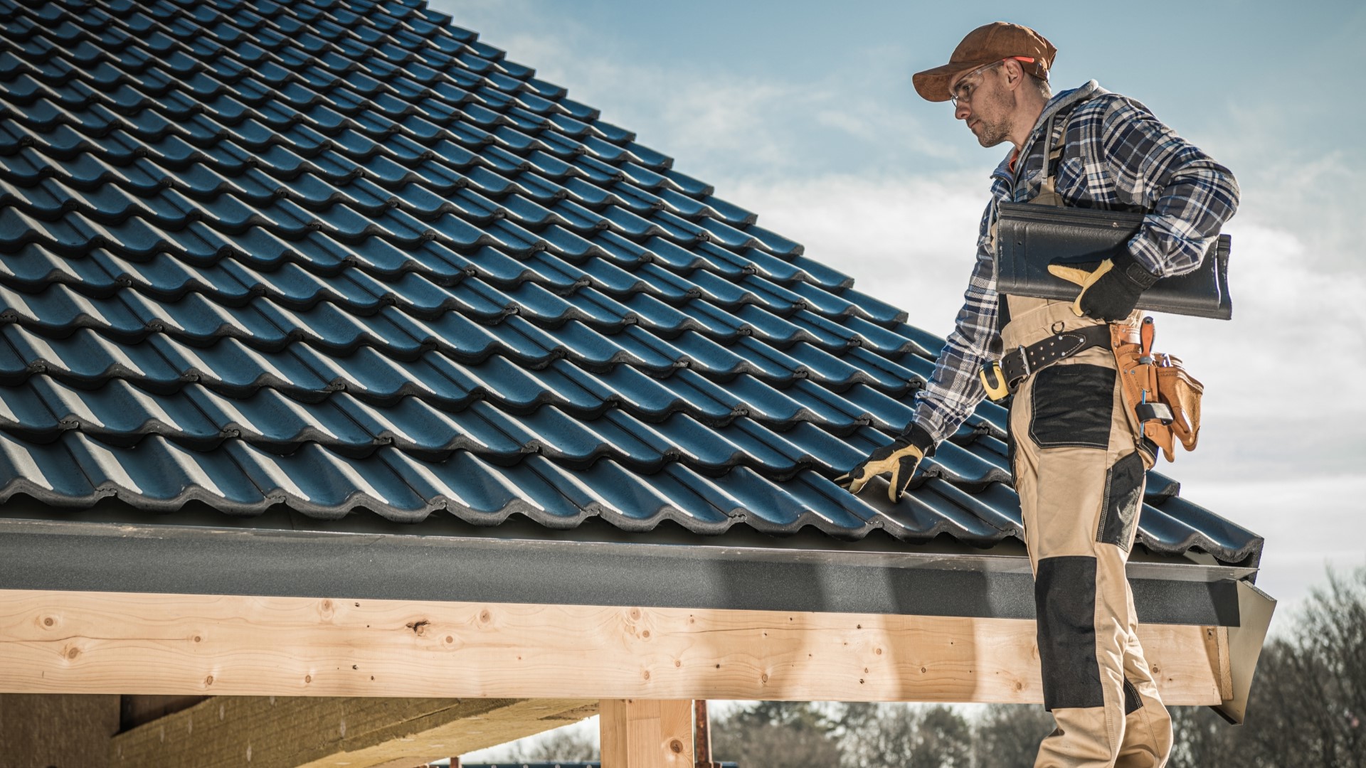 Roofer installing tiles on a residential roof.